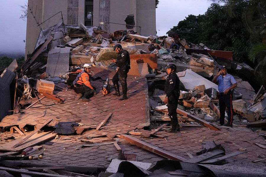 Equipos de rescate y los agentes de la policía municipal trabajan en el lugar donde se ha derrumbado un edificio en Caracas